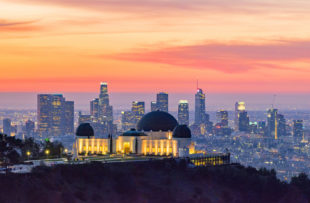 Los Angeles skyline at dawn with Griffith Park Observatory in the foreground